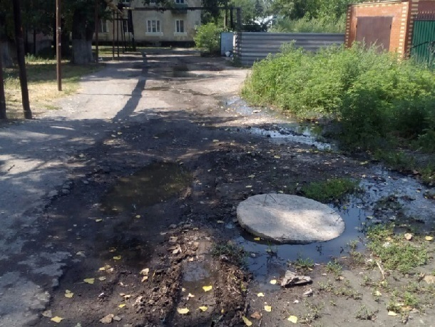 Едкий запах канализации, усиленный летним пеклом, стоит в переулке Мостовой в Шахтах